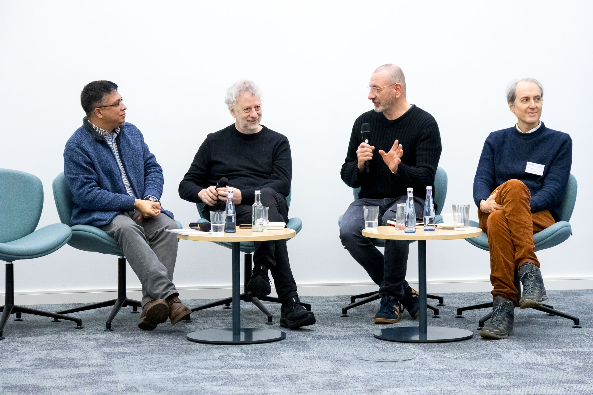 photo from the workshop 'Perpetrator Memory in Spanish culture', participants sitting at a table, a speaker presenting, a screen with slides in the back